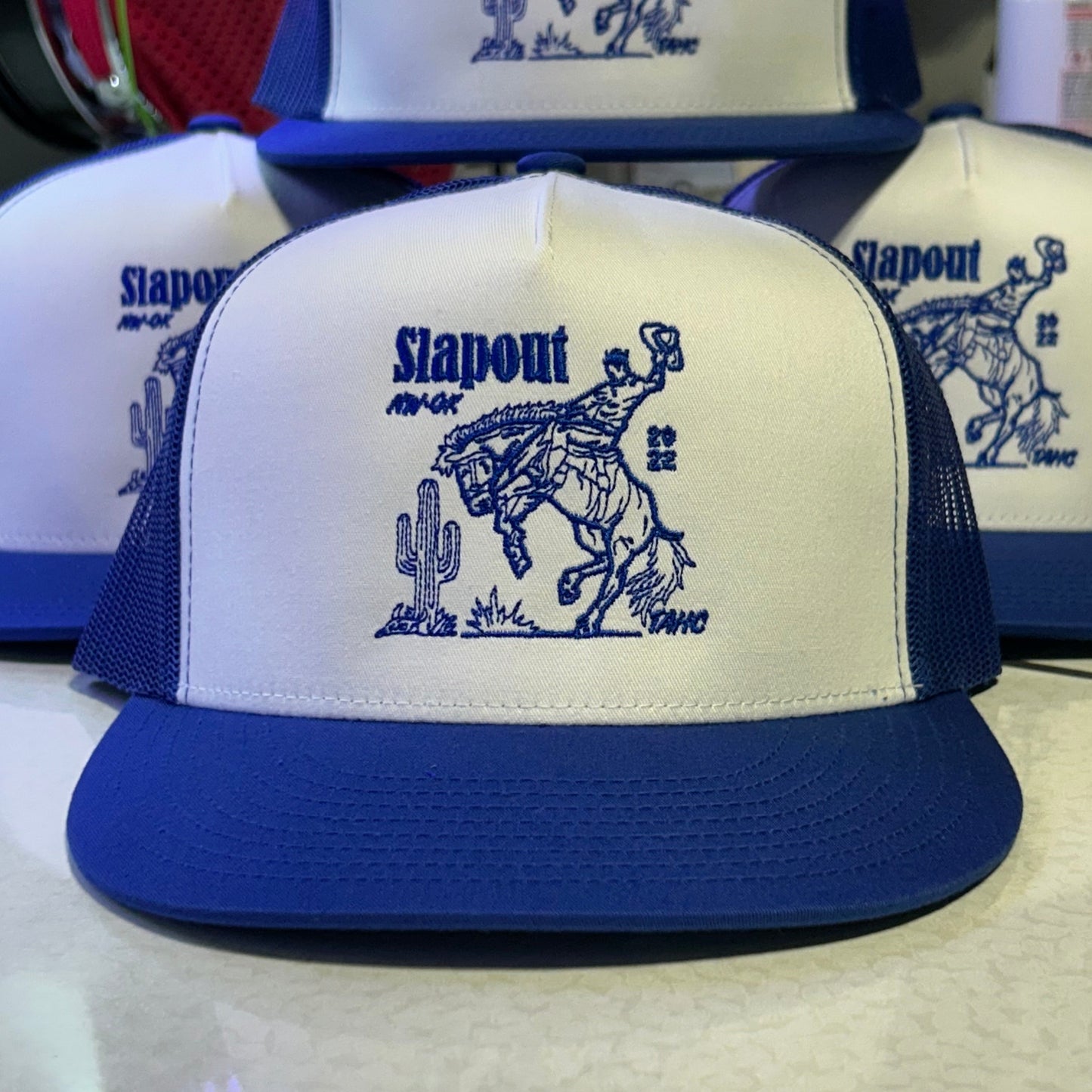 Close-up of a white and blue product with 'Slapout' branding on a blurred background.